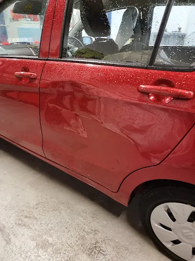 Red vehicle side panel before repair