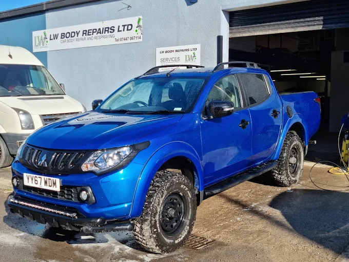 Freshly finished blue pickup outside the LW Body Repairs workshop